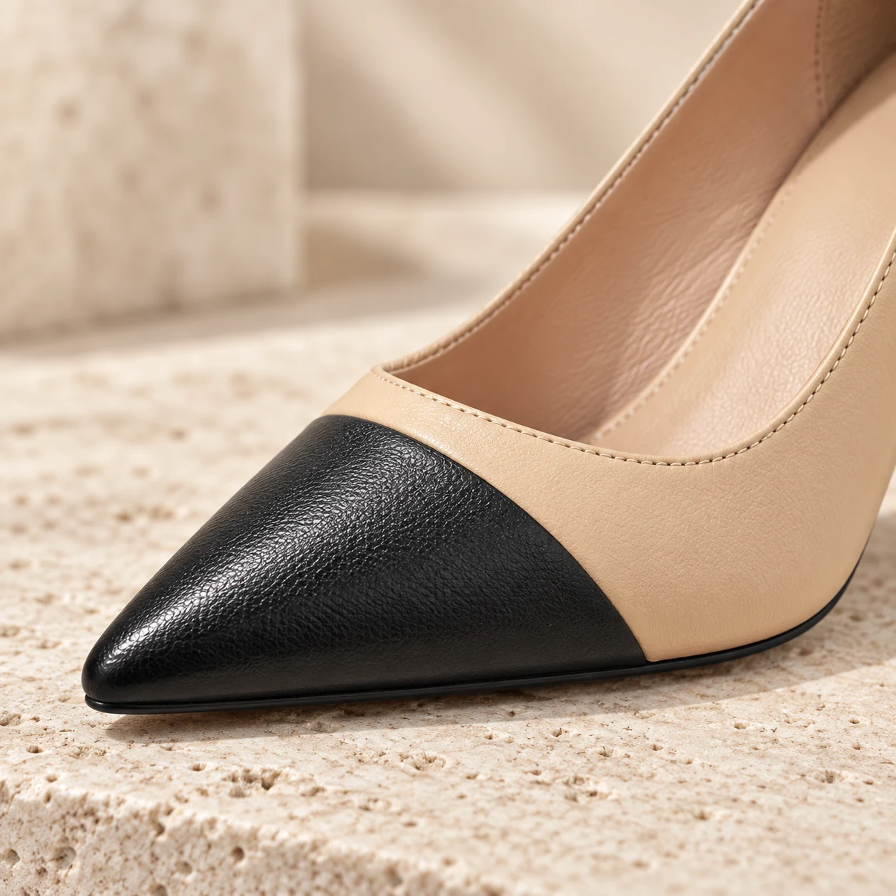 Close-up of the black leather pointed cap toe and beige leather vamp on the Beige Noir heel