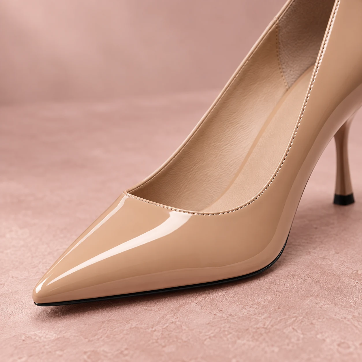 Close-up of the pointed toe and glossy beige pink patent finish