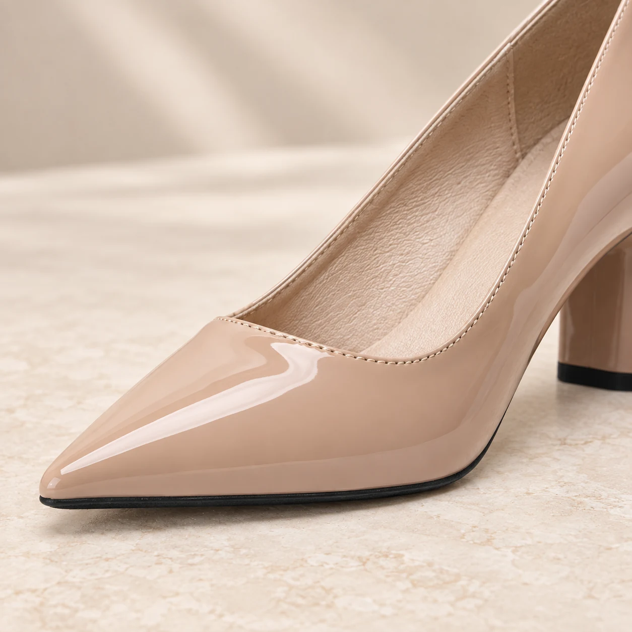 Close-up of Nude Block Heel pointed toe and glossy nude patent finish