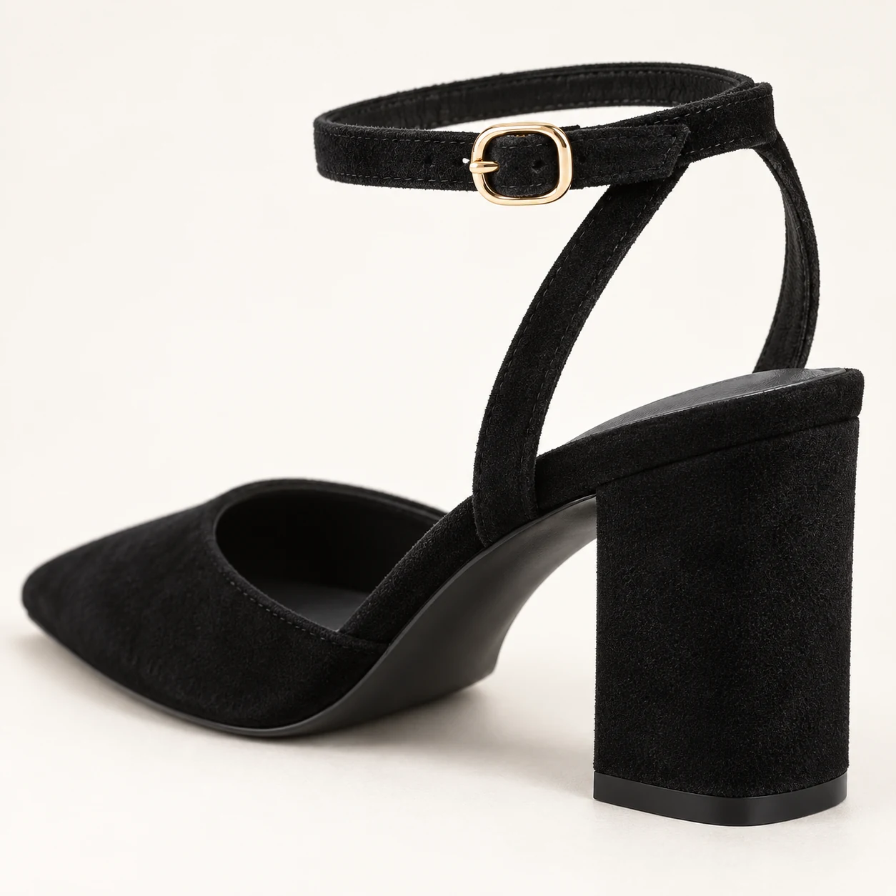 Close-up of the gold ankle buckle, crossed straps and black suede block heel